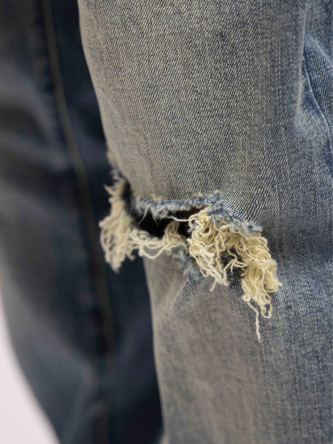 Close-up van het gescheurde detail op de knie van de jeans