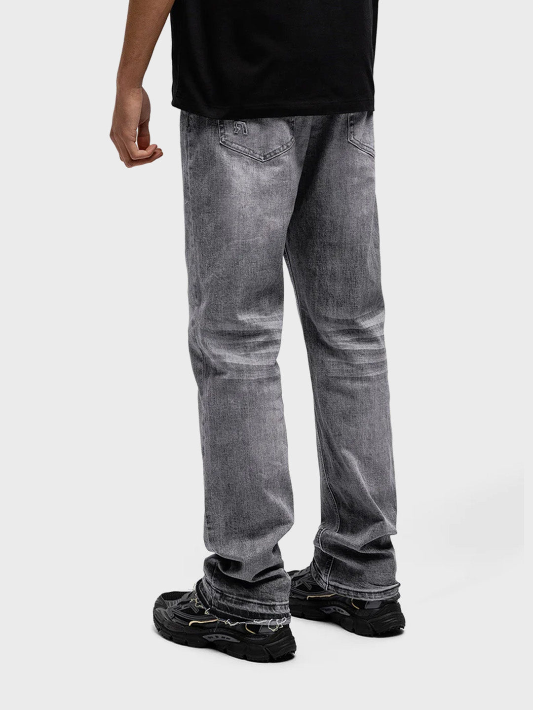 Model schuin achter Rivero Granite Embossed Jeans met embossed R-logo op achterzak