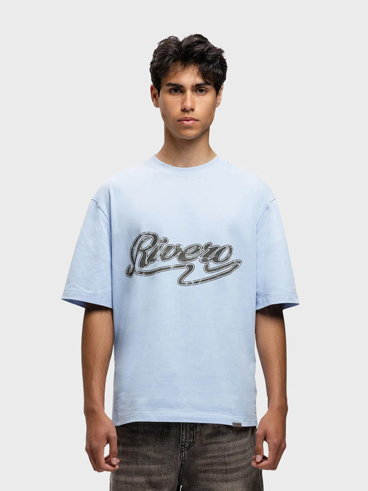 Model draagt Rivero Script T-Shirt in lichtblauw – vooraanzicht