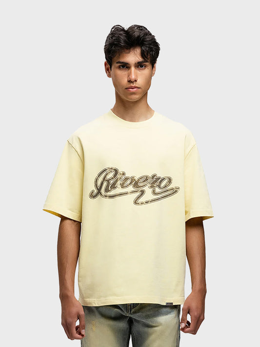 Model draagt Rivero Script T-Shirt in zachtgeel – vooraanzicht