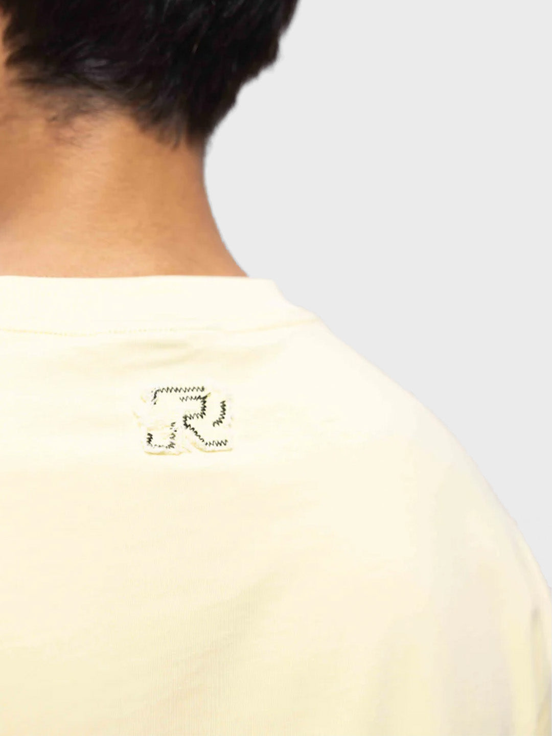 Close-up van de subtiele branding op de achterkant van het T-shirt