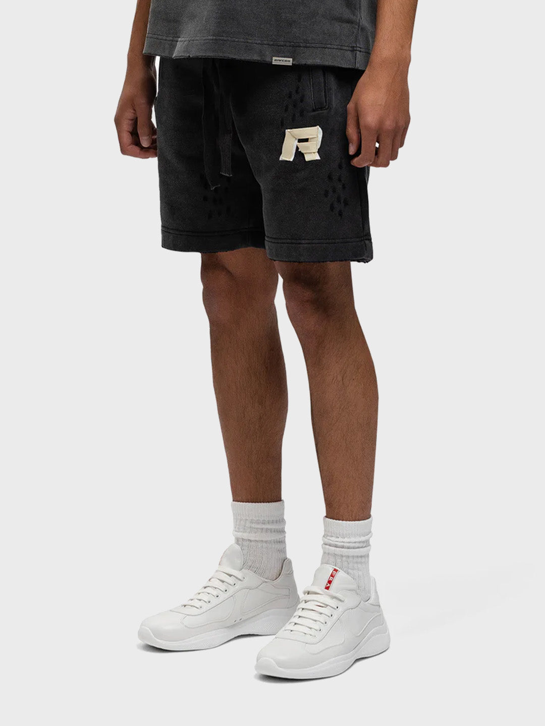 Model draagt Rivero Signature Taped Shorts Washed Black – schuin vooraanzicht