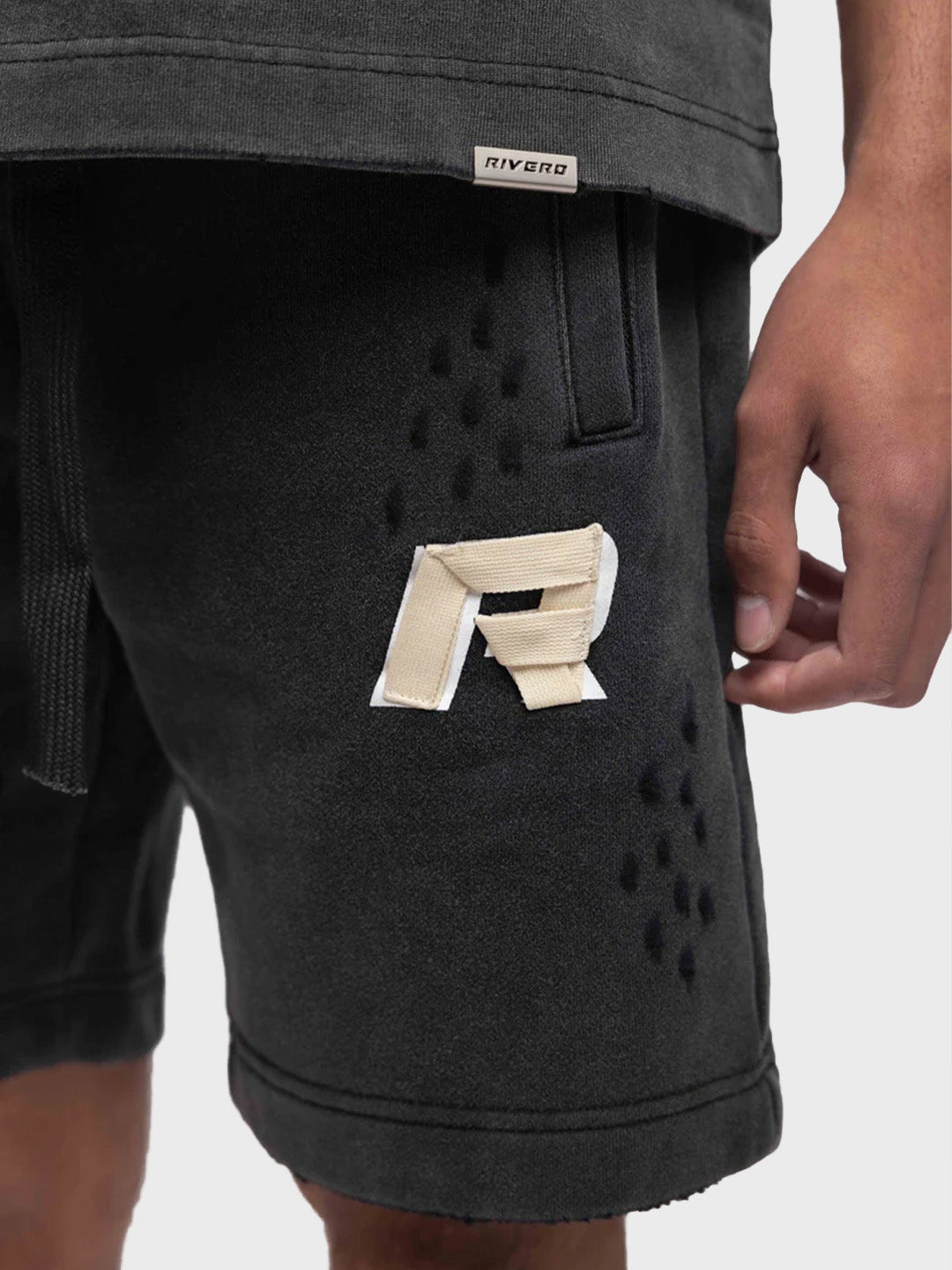 Close-up van tape-stijl logo, gewassen look en distressed details op de short