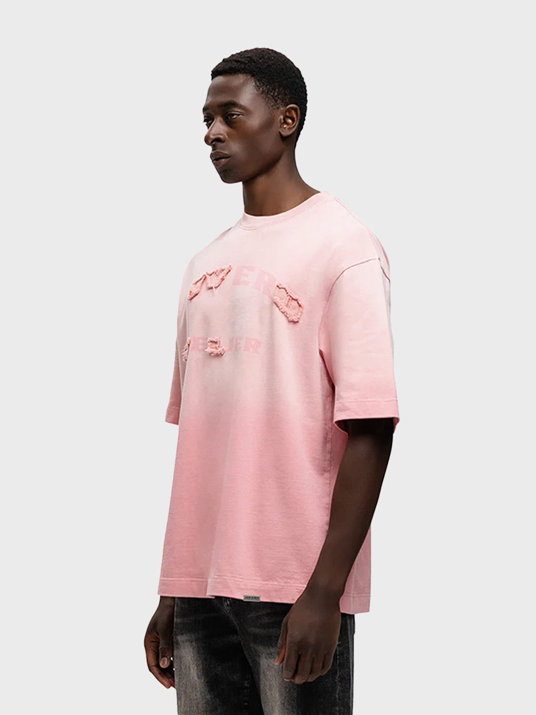 Model draagt Rivero Statement T-Shirt in gewassen roze – schuin vooraanzicht