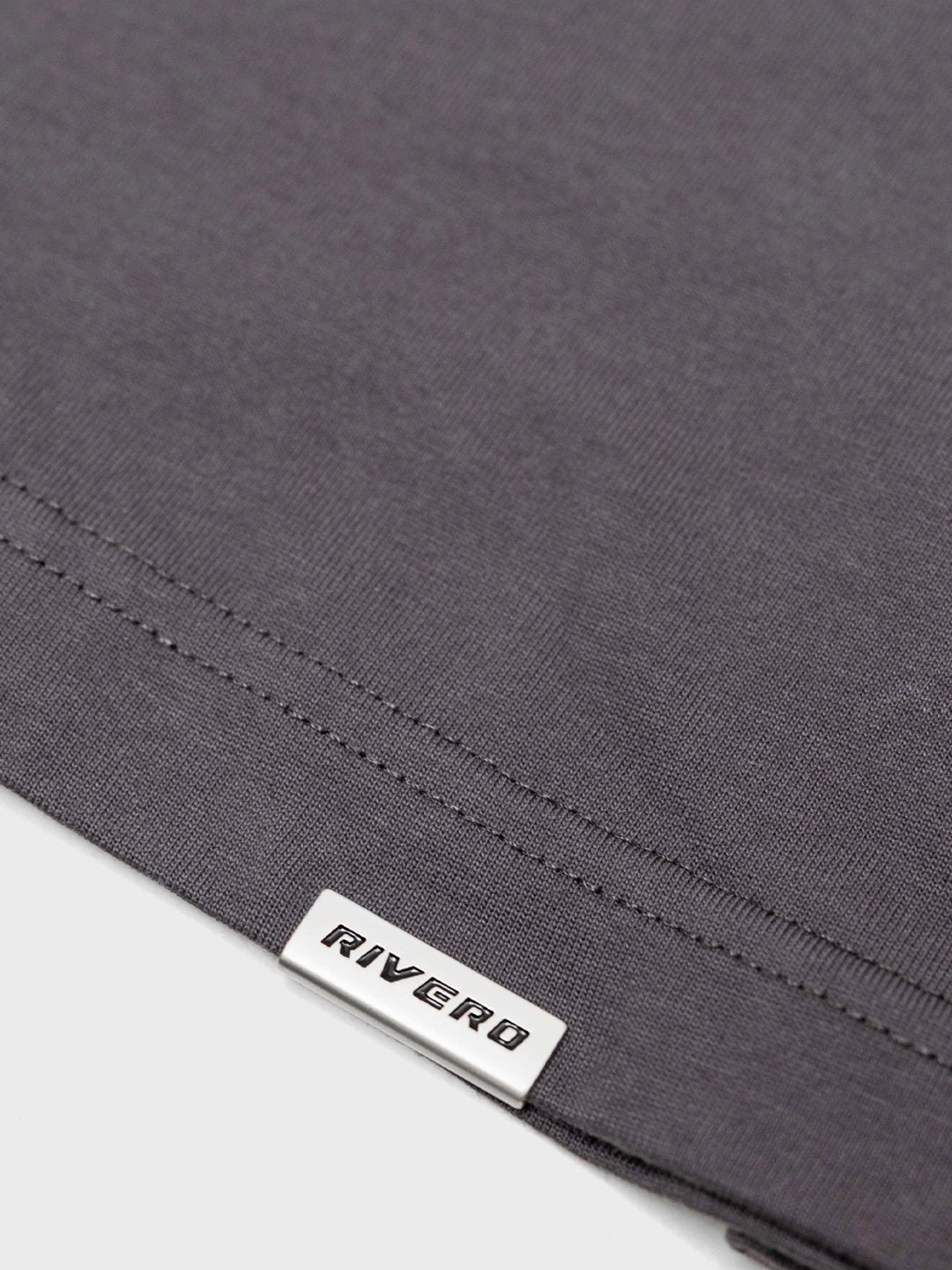 Close-up metalen tag aan onderkant van Rivero longsleeve