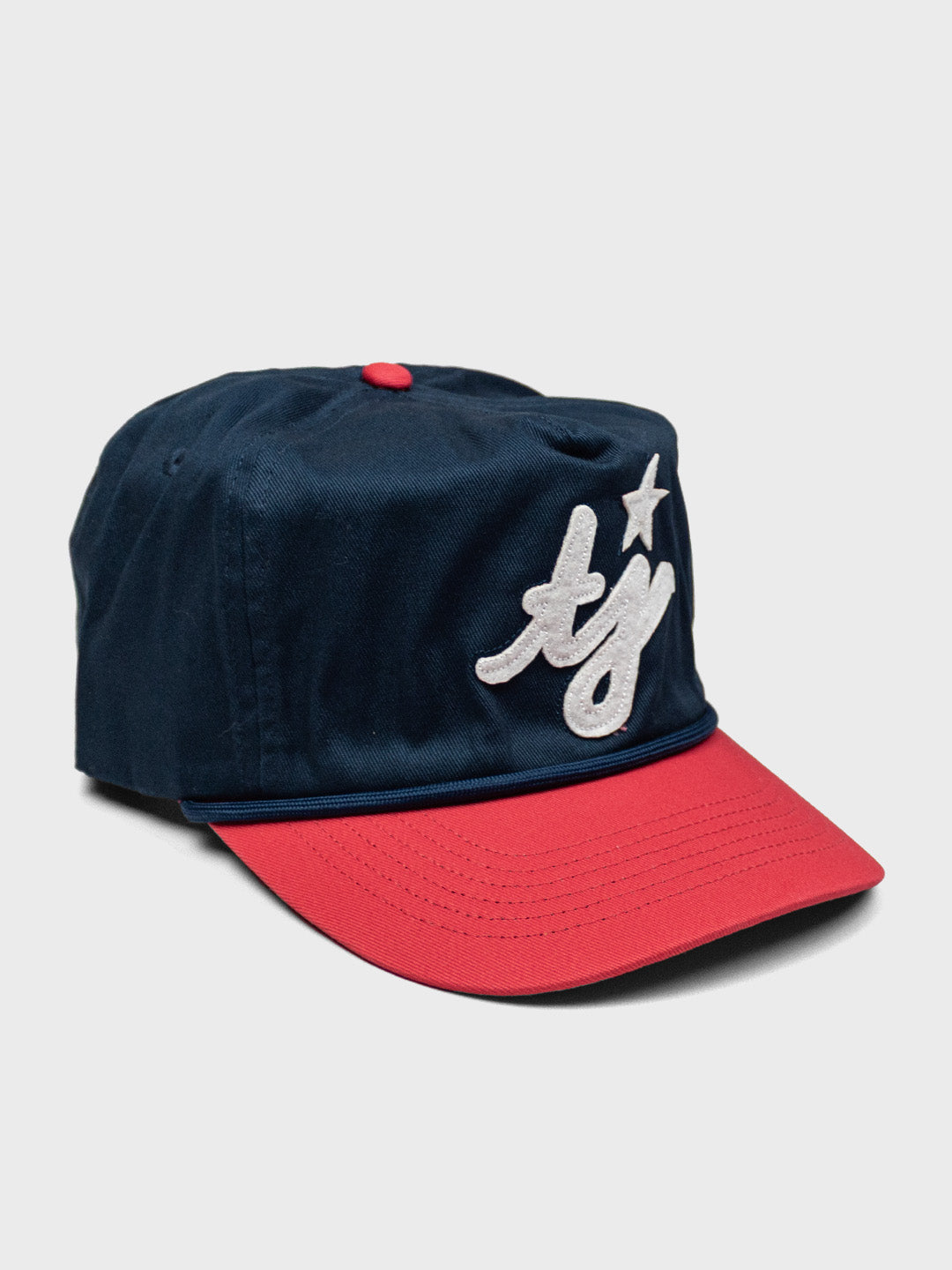 TwoJeys Dinger Cap schuin vooraanzicht met rode brim en vintage koord