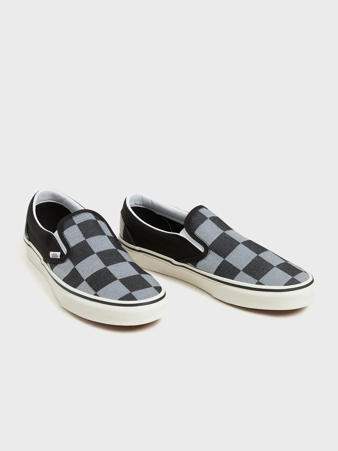 Schuine vooraanzicht van het paar Vans Slip-On sneakers met checkerboard print in zwart/grijs